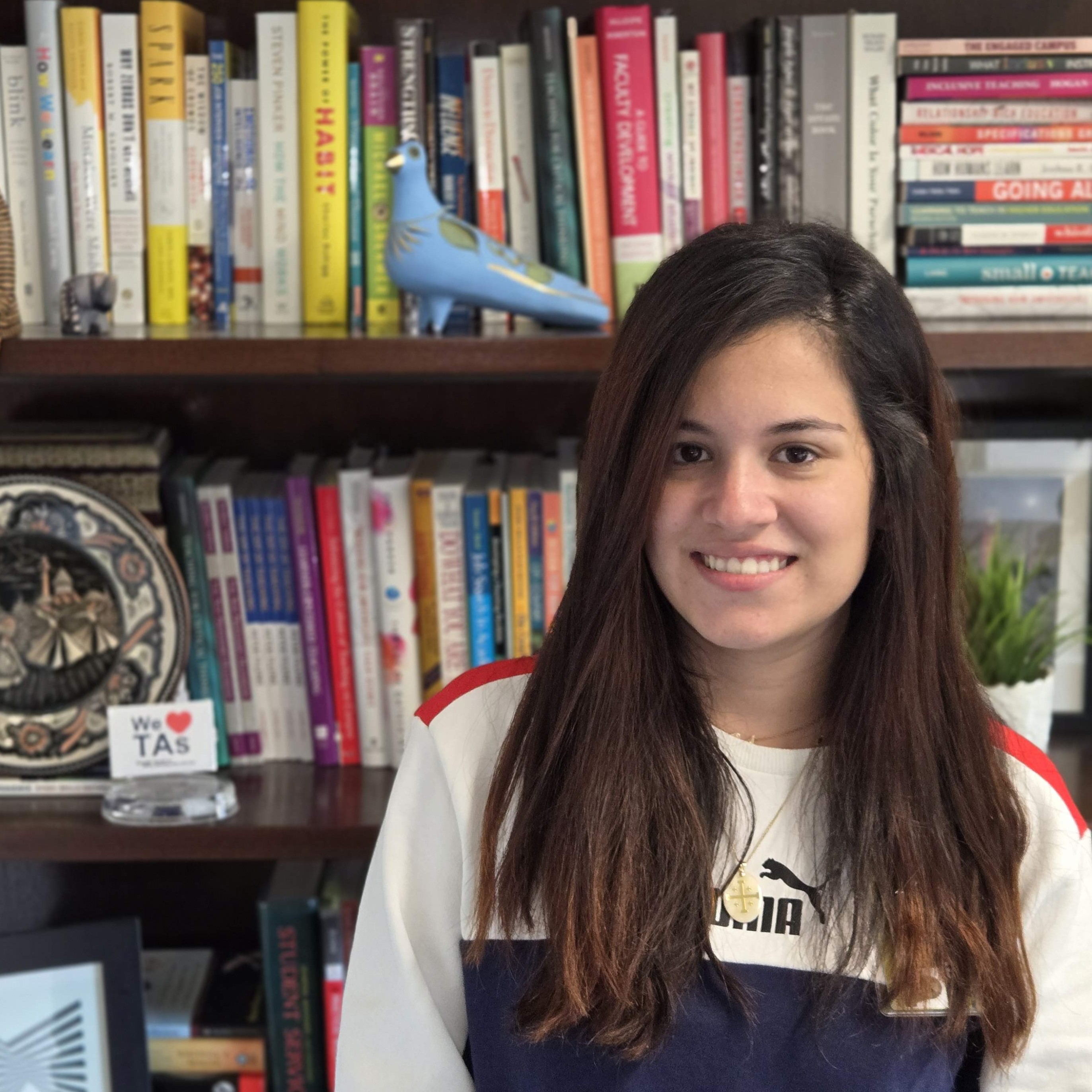 Ianne smiling in front of a bookshelf